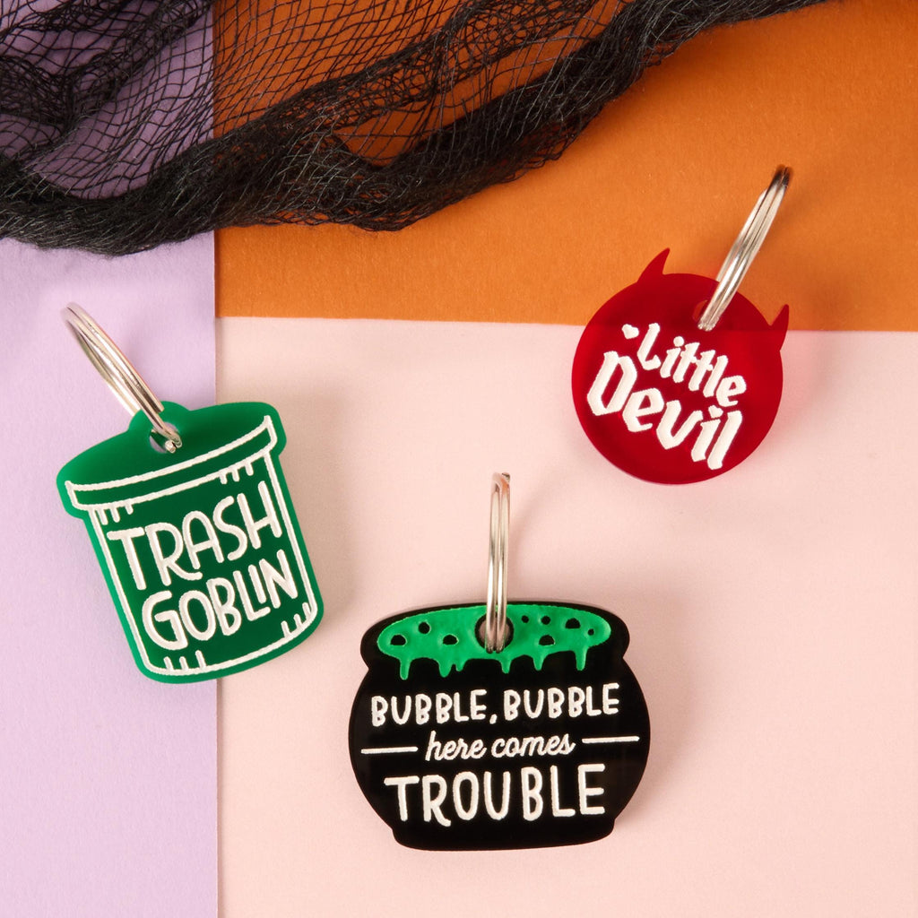 Set of three Halloween pet ID tags including “Trash Goblin,” “Little Devil,” and “Bubble, Bubble, Here Comes Trouble” designs