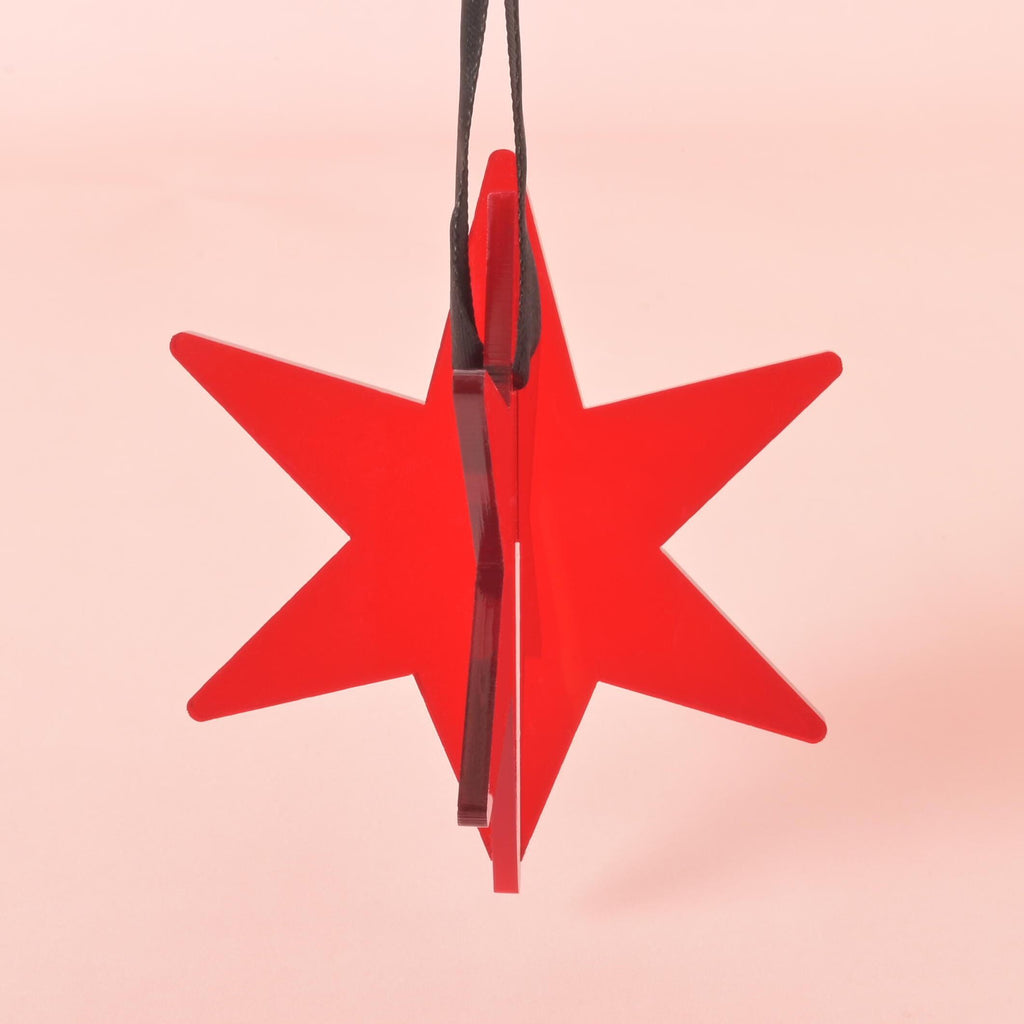 Side view of 3D red acrylic star ornament with black ribbon – modern and minimalist holiday tree decoration