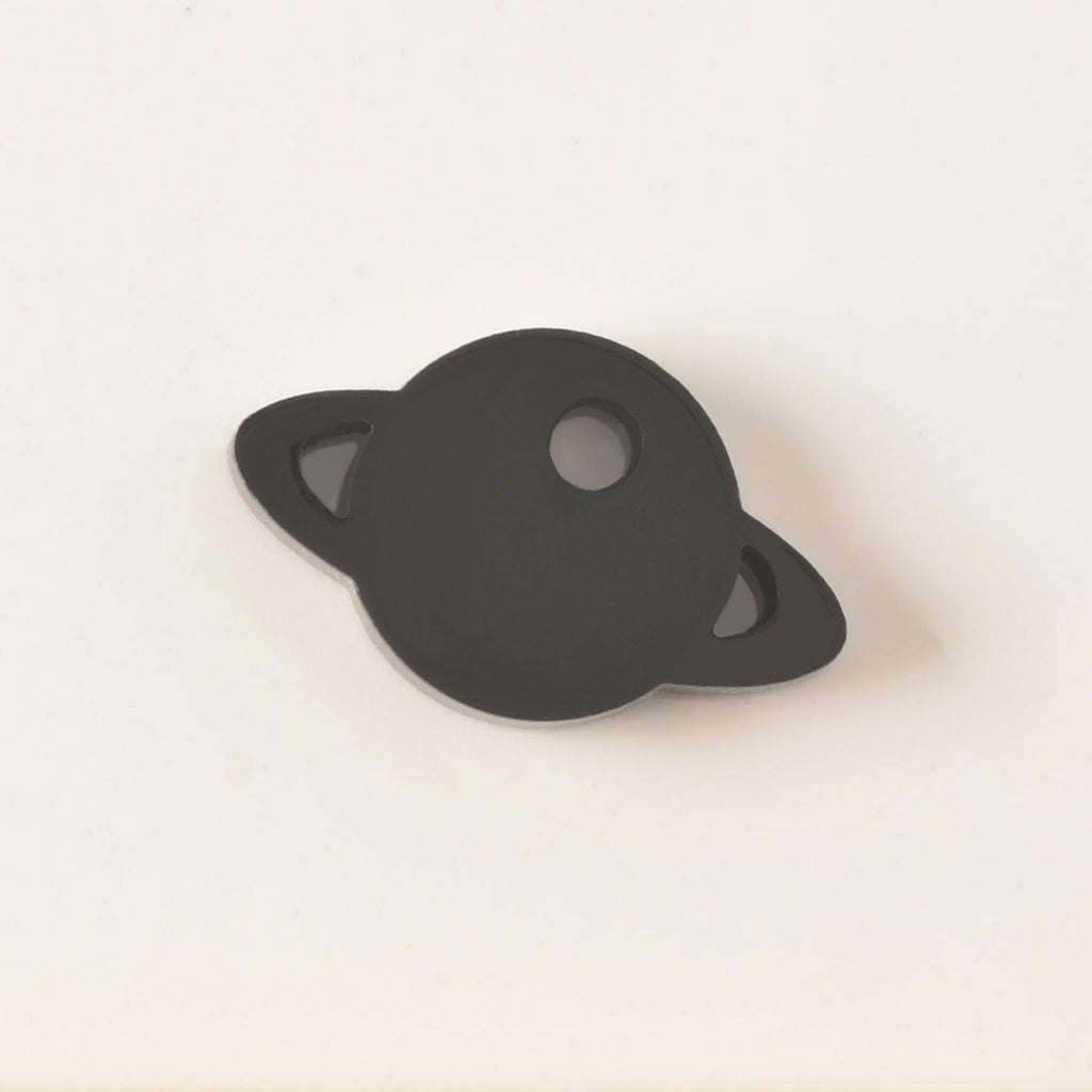 black Saturn-shaped mini charm add on for pet tags on solid white background