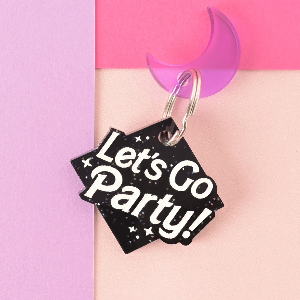 Glitter black Personalized pet tag that reads "Let's go party!" with a purple moon mini charm on a color blocked background.