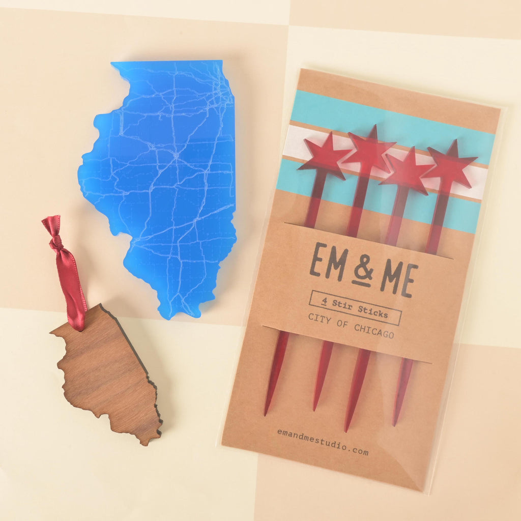 Set of four red star Chicago flag drink stir sticks in packaging, displayed with a blue Illinois state-shaped acrylic coaster and a wooden Illinois state ornament with red ribbon.