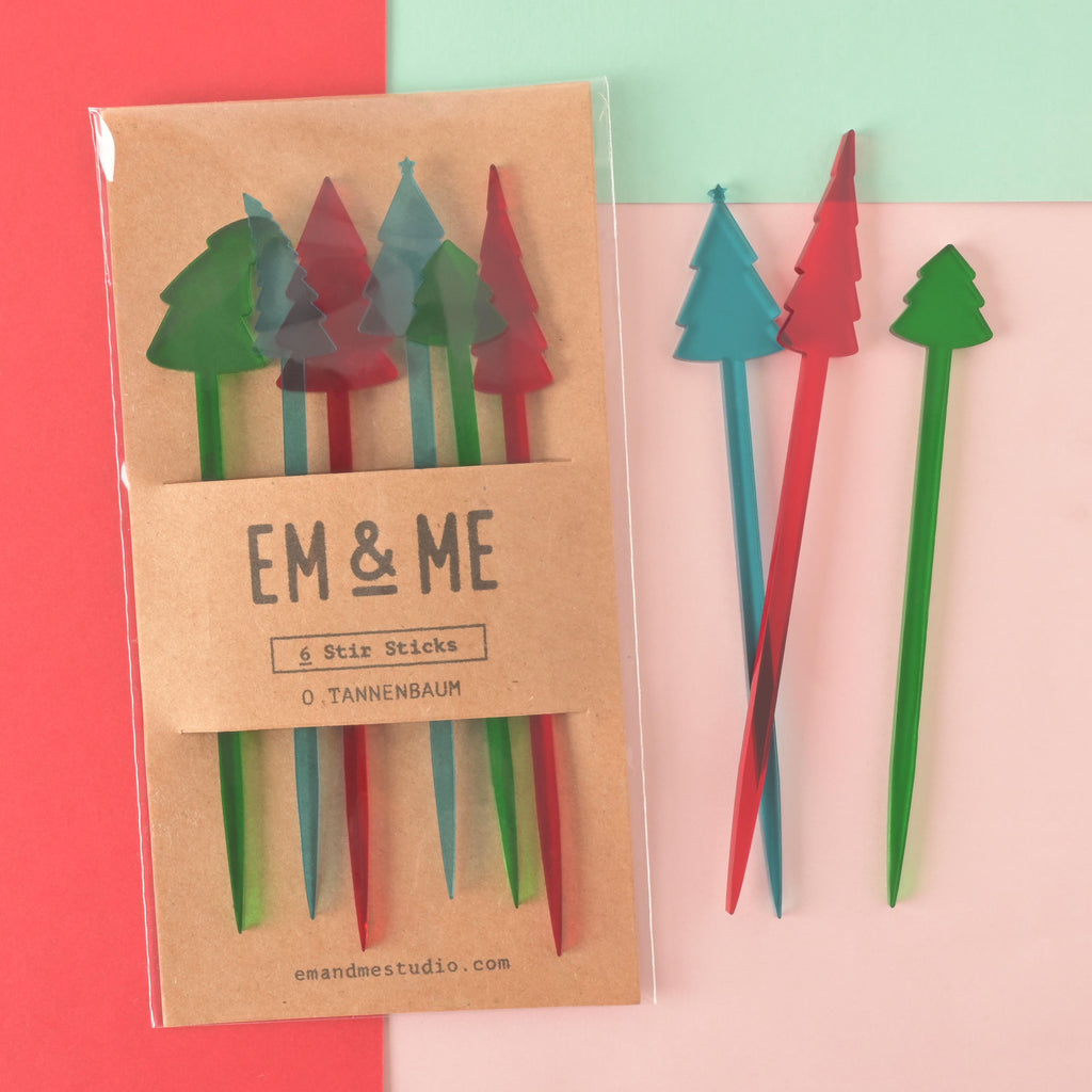 Colorful acrylic Christmas tree drink stirrers in red, green, and teal, displayed in eco-friendly packaging labeled EM & ME – perfect for festive cocktails or hot cocoa.