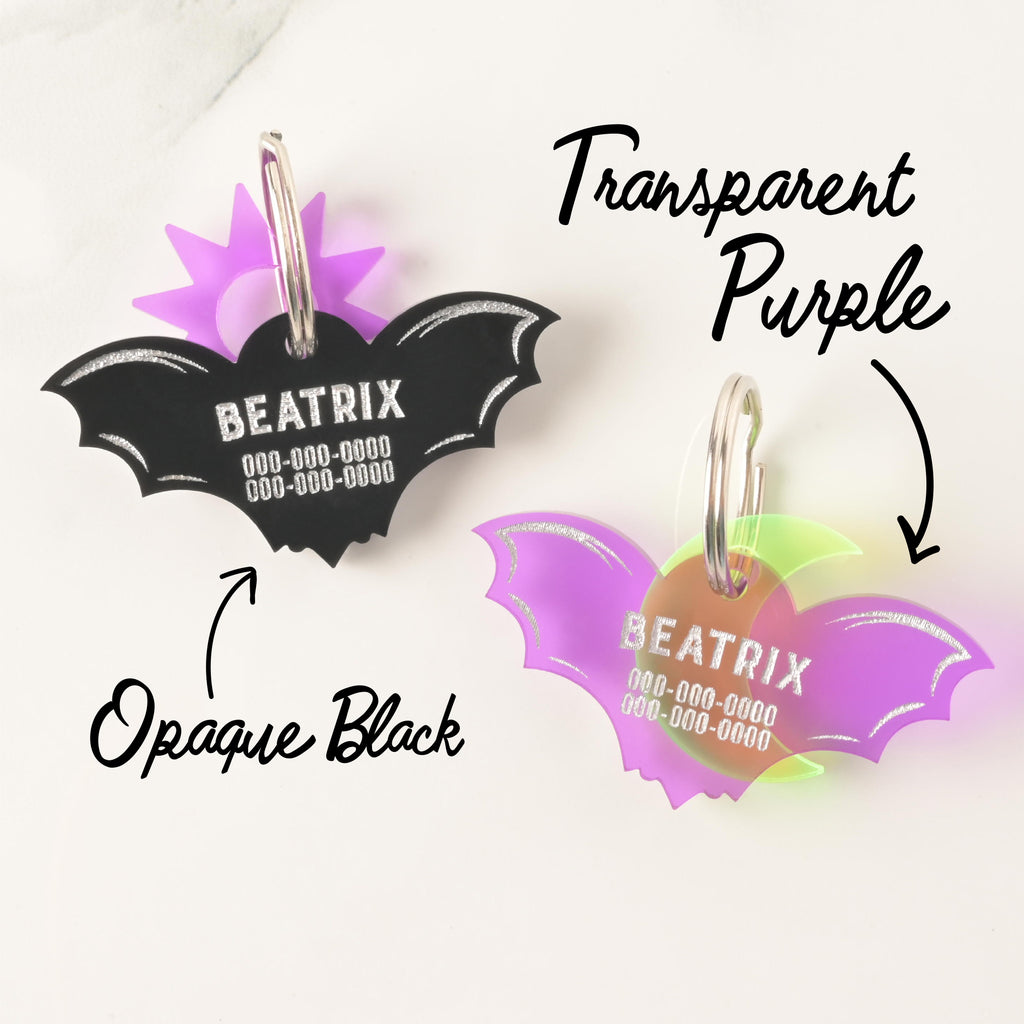 Custom acrylic bat pet ID tags in Opaque Black and Transparent Purple, engraved with name and numbers, ideal for gothic or Halloween-themed pet accessories.