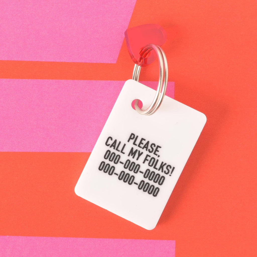 Back of Lucky Ace pet ID tag engraved with text “Please call my folks!” and phone numbers, on a bold red and pink background.