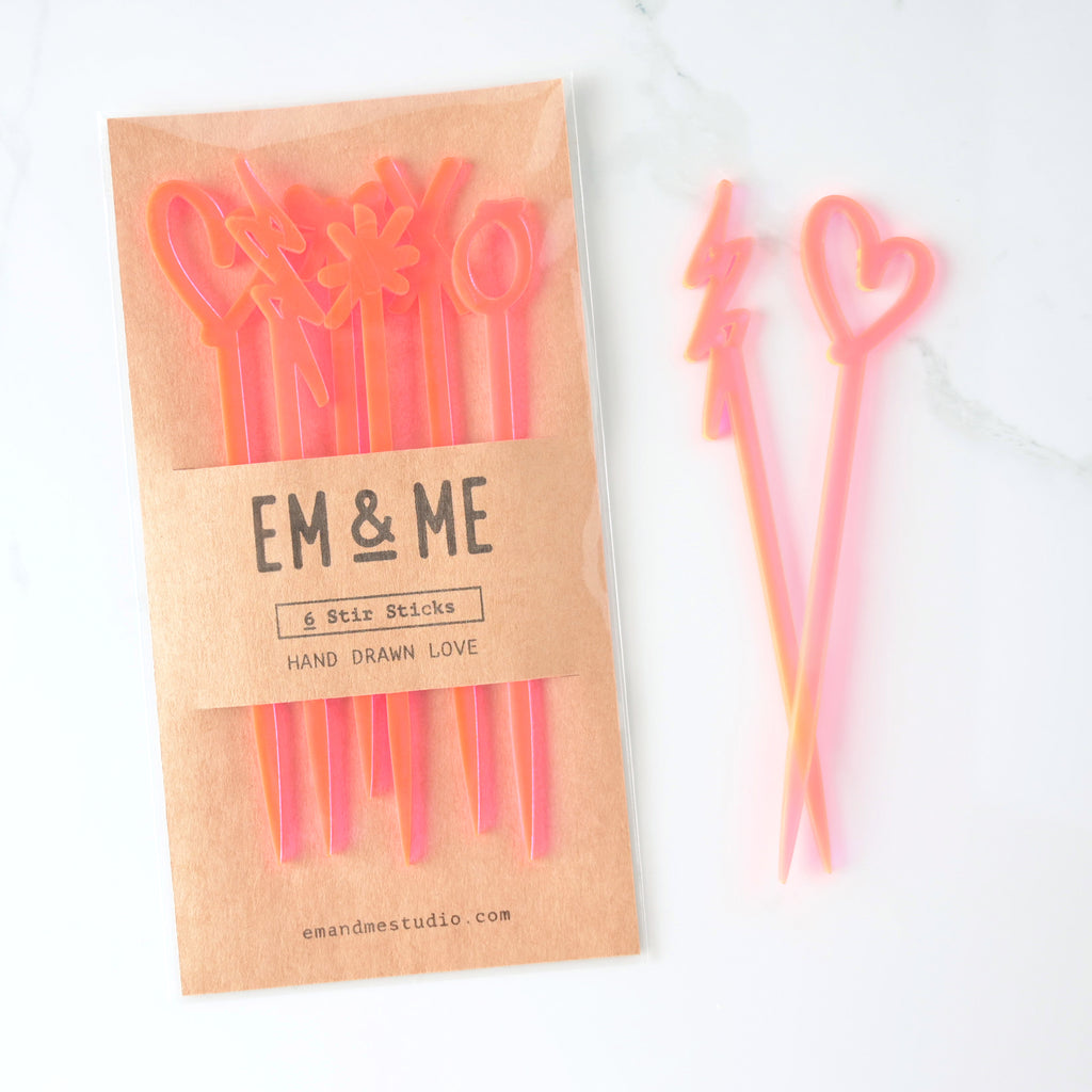 Set of 6 hand drawn love cocktail stirrers. Fluorescent pink perfect for wedding and bachelorette parties. two single sticks off to side on marble background