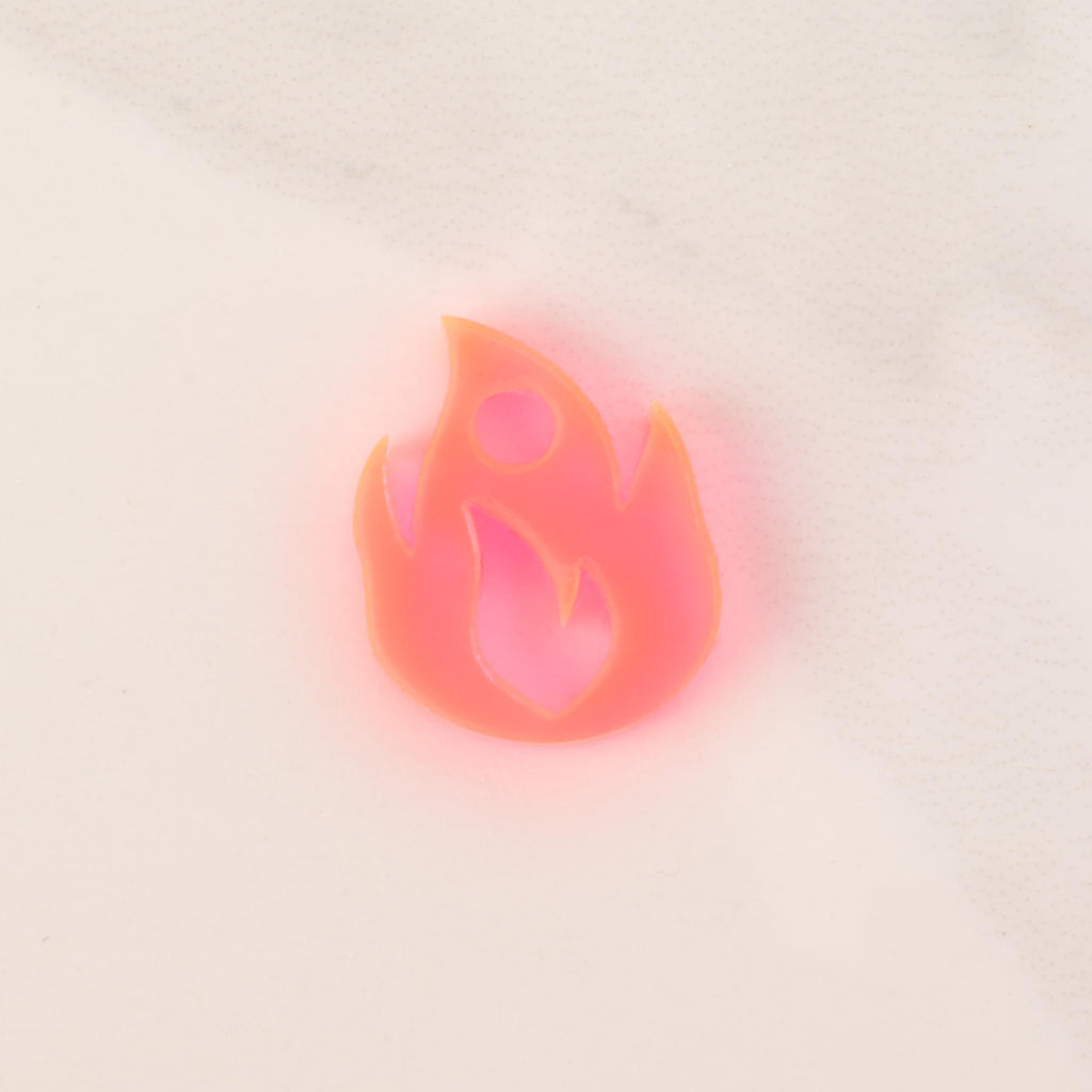 fluorescent pink flame-shaped mini charm on solid white background