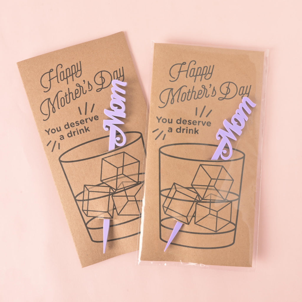 
Based on the image you've uploaded, here are the SEO values for the title and alt text.

SEO Title
Set of "Happy Mother's Day" Cocktail Stirrer Gift Cards 👩‍👧‍👦💖

This title is concise and accurately describes the product. It uses relevant keywords like "Mother's Day," "cocktail stirrer," and "gift cards" to improve search visibility.

Alt Text
A set of two "Happy Mother's Day" gift cards, each with a drawing of a glass of ice and a purple "Mom" stirrer attached. The cards are sealed in plastic and are