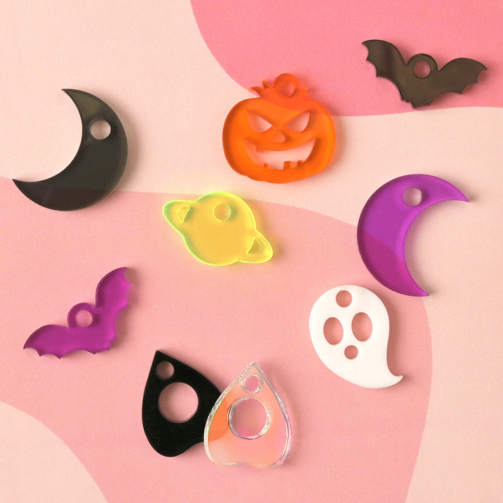 Halloween acrylic charms for dog and cat collar accessories. Charms shown are a ghost, pumpkin, bats, crescent moons, and planchette shapes.