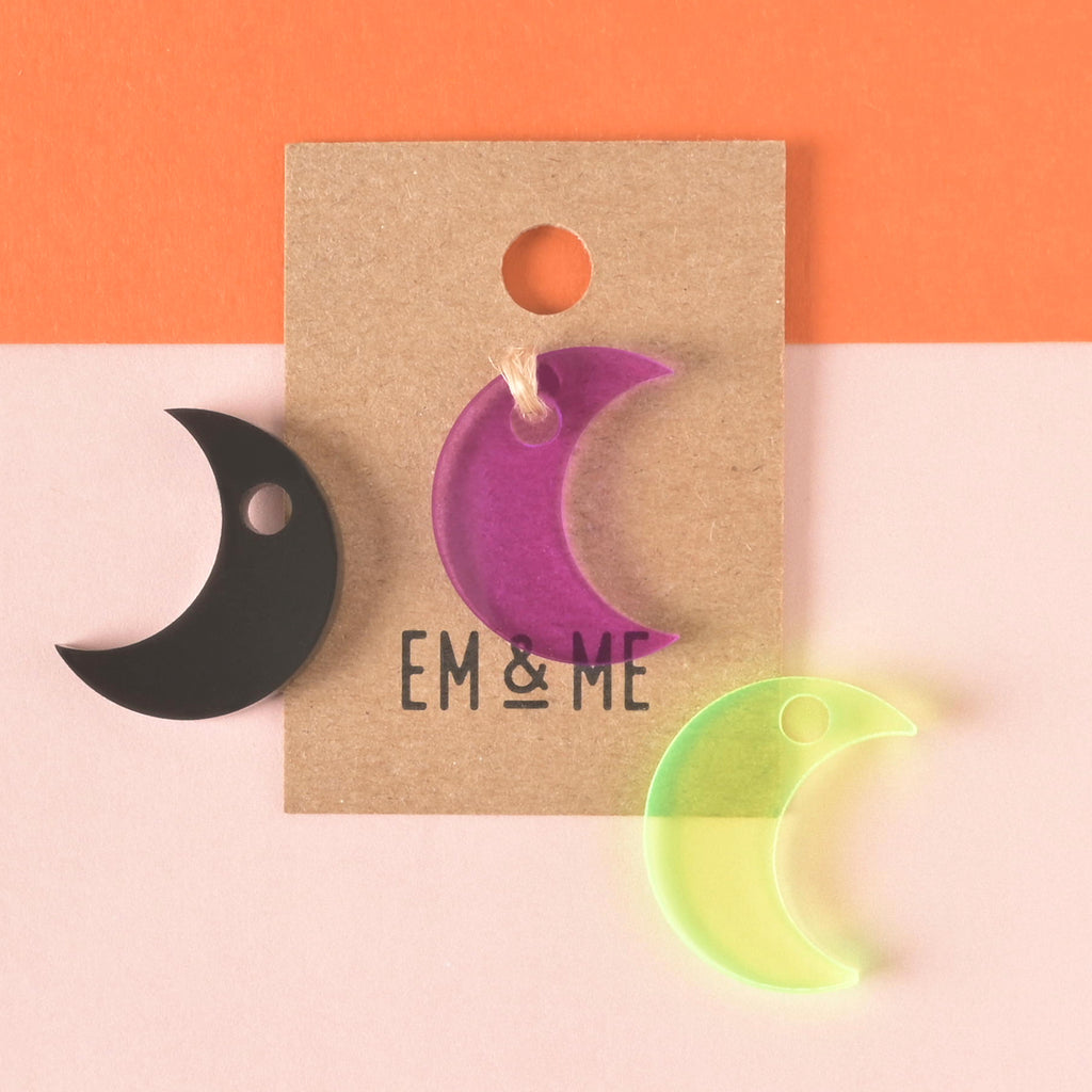 Purple moon-shaped seasonal mini with black and fluorescent green moons off to the side on color blocked background