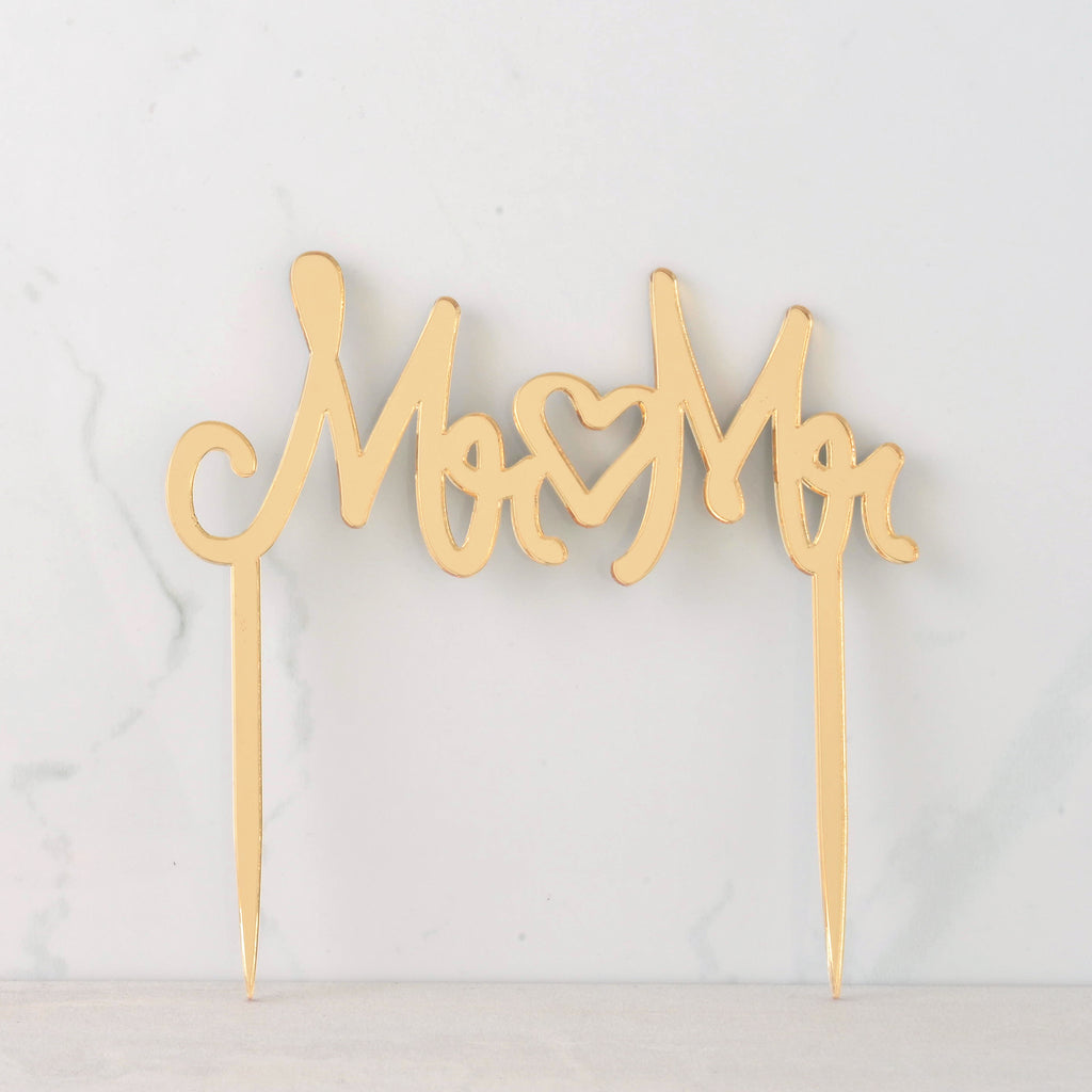 mirror gold cake topper that reads "MR MR" with a heart in the middle for wedding. Inclusive LGBTQIA+ celebration.