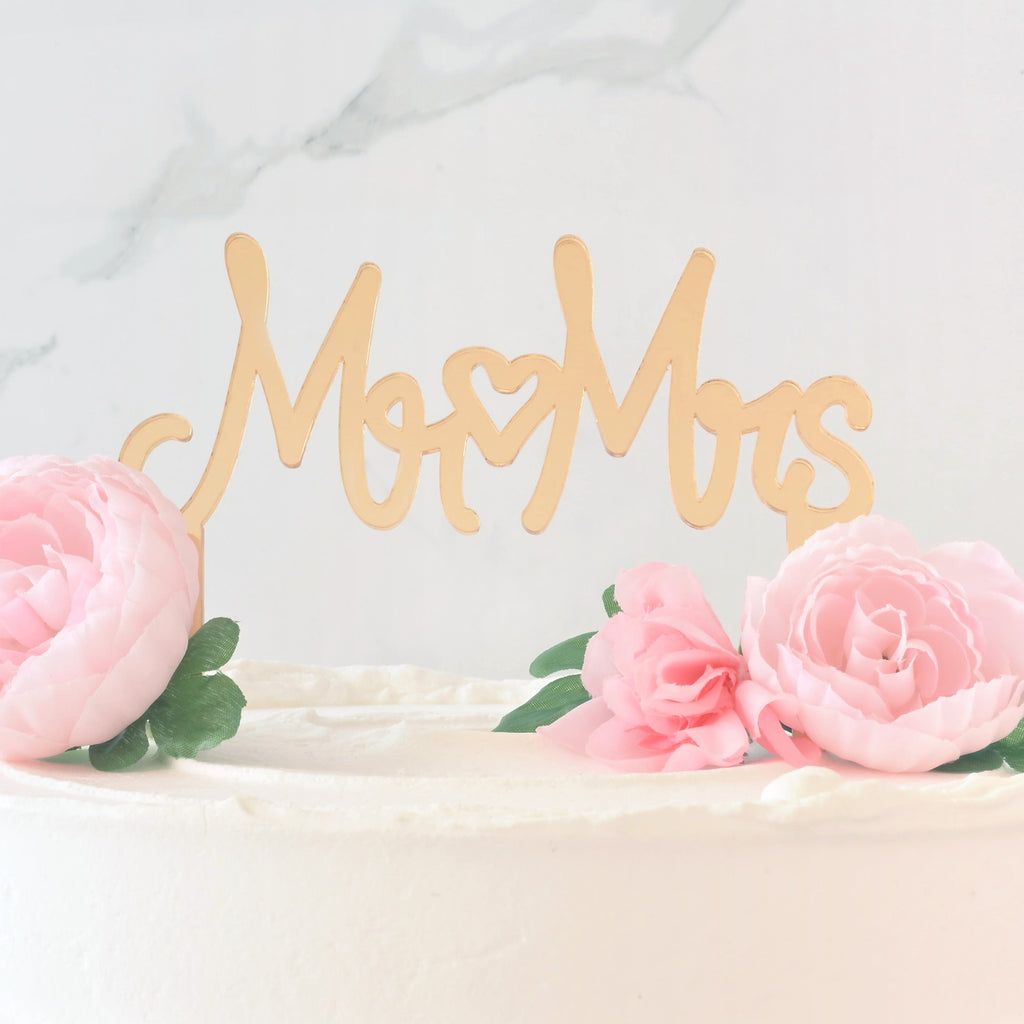 close up of Mirror gold cake topper in a cake that reads "Mr Mrs" with a heart in the middle for wedding cake.