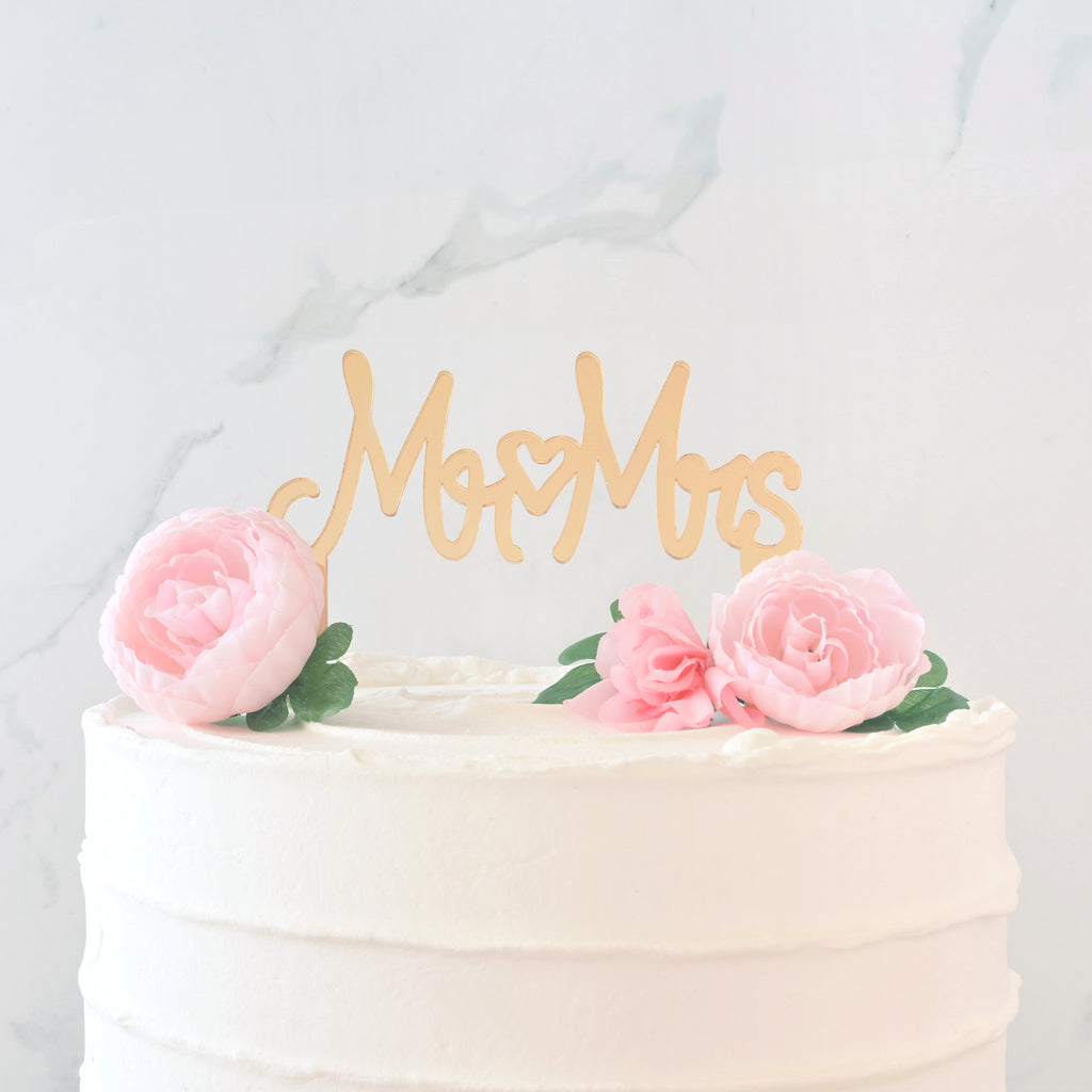 Mirror gold cake topper in cake  that reads "Mr Mrs" with a heart in the middle for wedding cake.