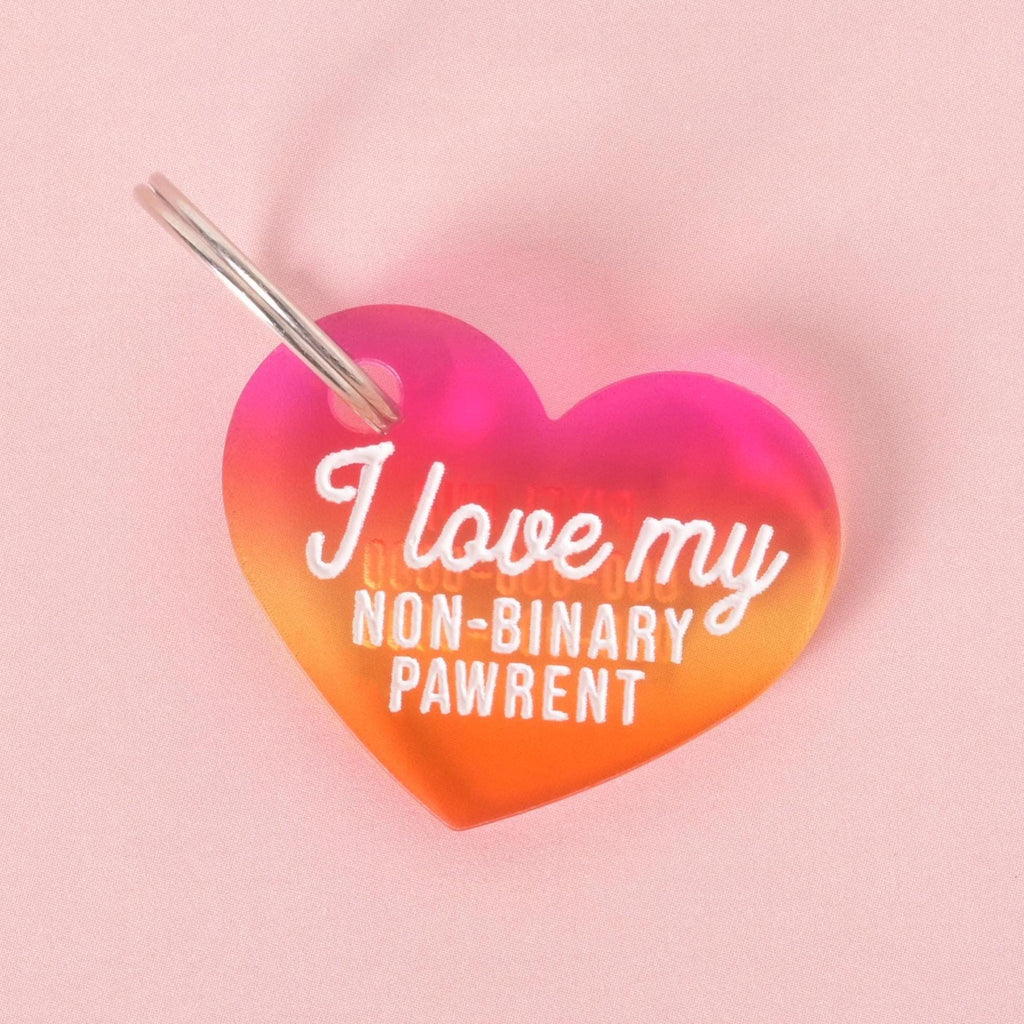 Heart-shaped acrylic pet ID tag with a pink-to-orange gradient that reads “I love my non-binary pawrent.”
