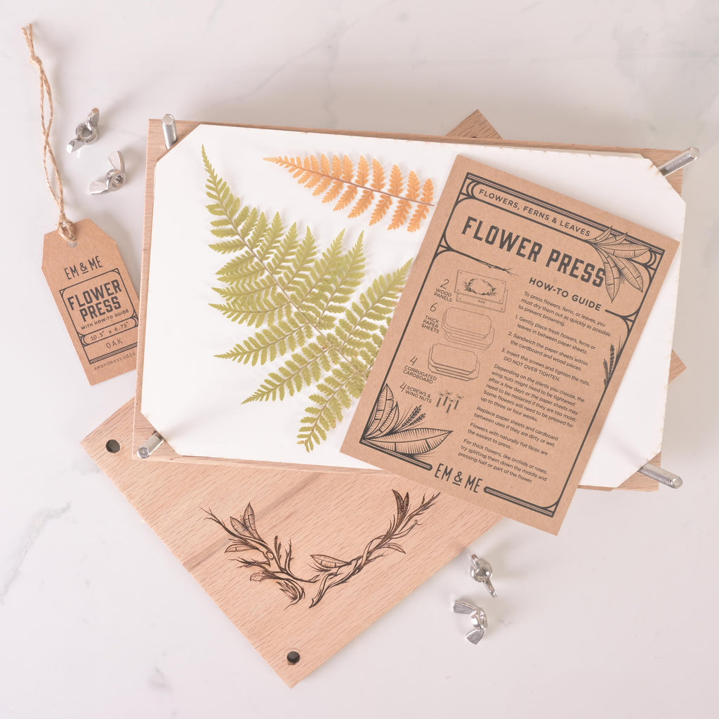 Personalized oak flower press kit shown in use with pressed fern leaves and Em & Me Studio how-to guide