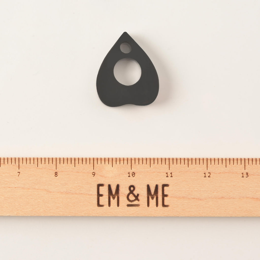 Black ouija planchet-shaped pet mini charm add on with a wooden ruler that reads "EM & ME" on solid white background