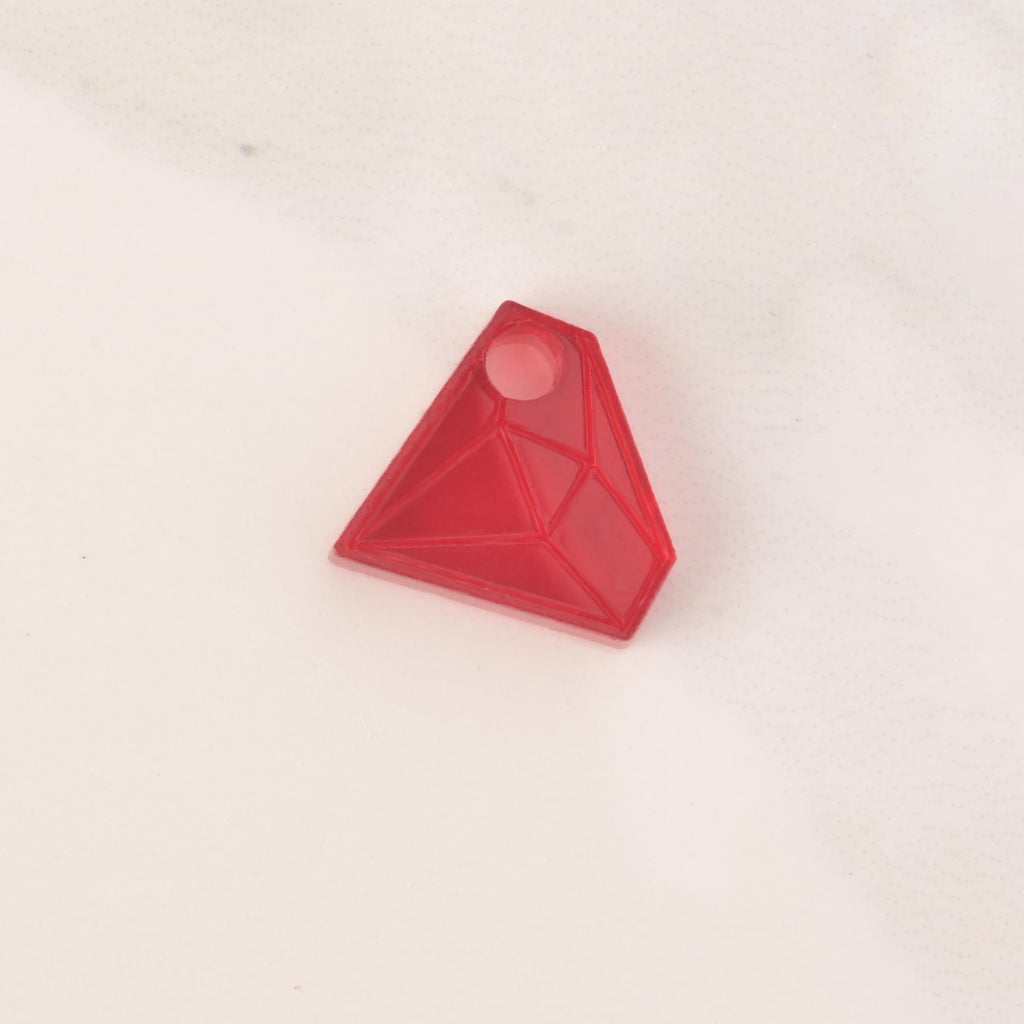 red acrylic diamond-shaped mini charm with hole on solid white background