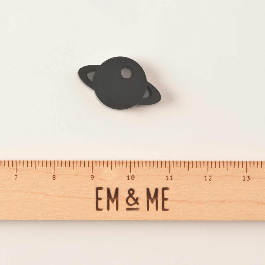 Black Saturn-shaped mini charm add on for pet tags with wooden ruler that reads "EM & ME" on solid white background
