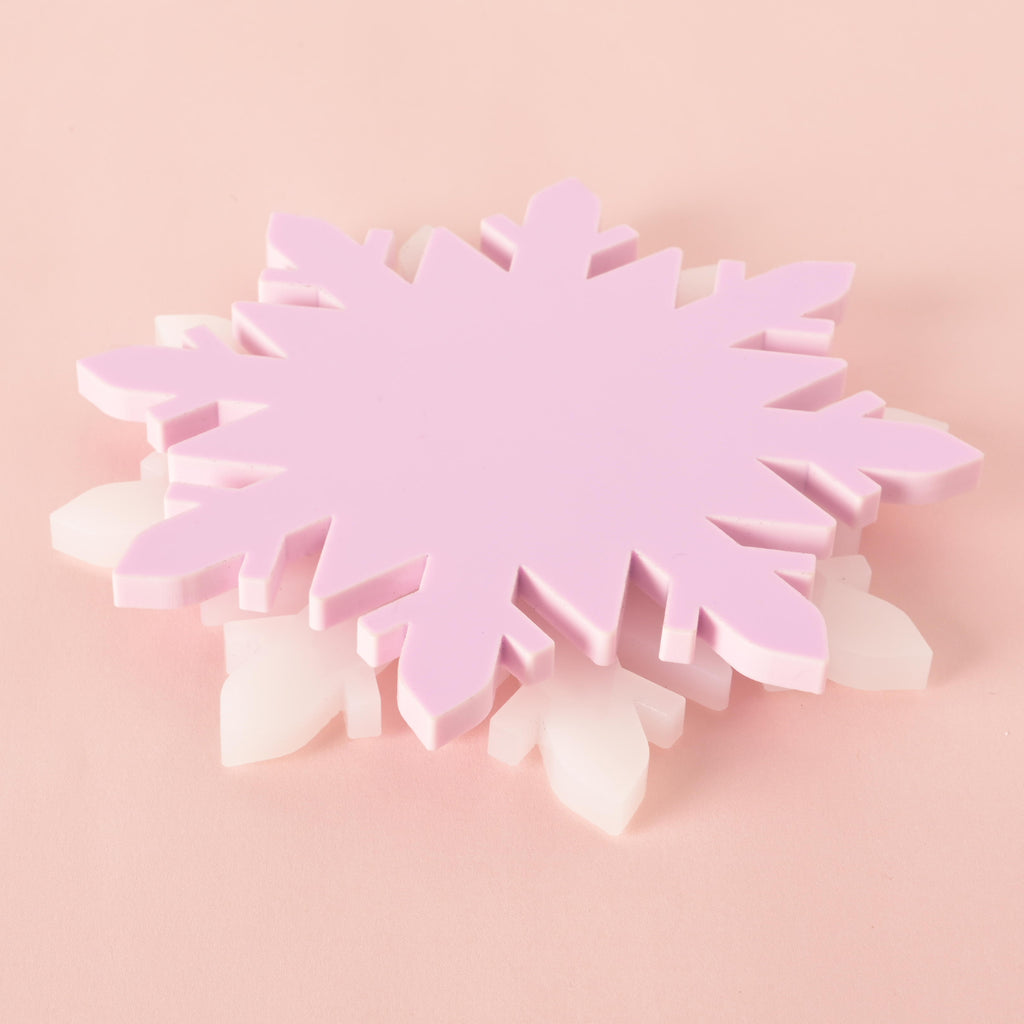 Stack of pink and white acrylic snowflake coasters, durable Christmas table decor and festive winter drink holders for holiday entertaining. Lavender