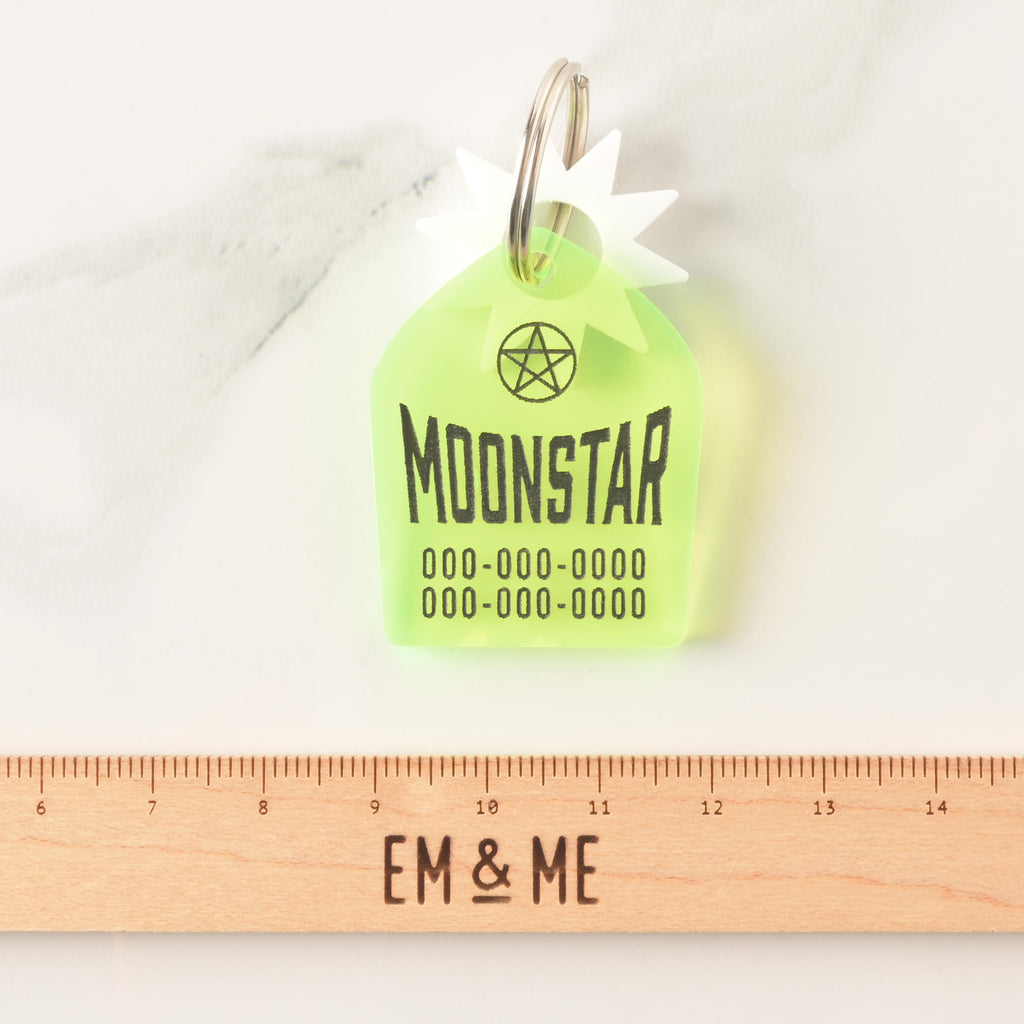 Fluorescent green gravestone-shaped personalized pet tag with wooden ruler that reads "EM & ME" on marble background 
