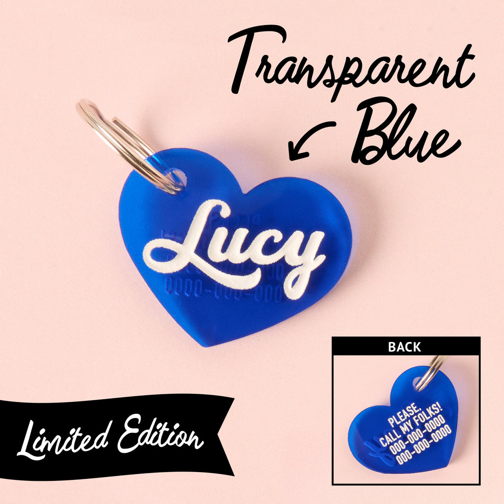 Limited edition transparent blue heart-shaped pet ID tag with engraved name Lucy on front and contact info on back, silver keyring attached.