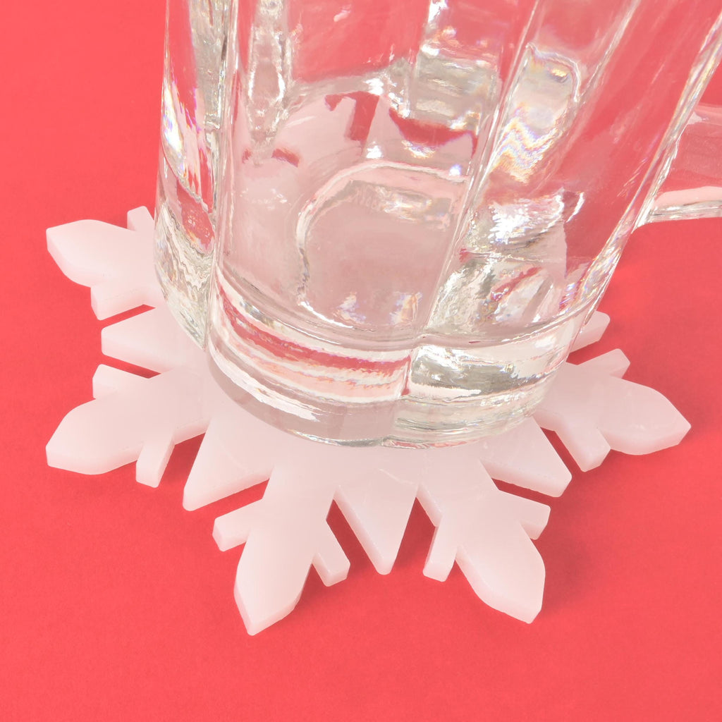 Snowflake coaster or trivet, Winter translucent white acrylic coaster
Glass mug resting on a white snowflake-shaped coaster, festive winter  decor accessory 