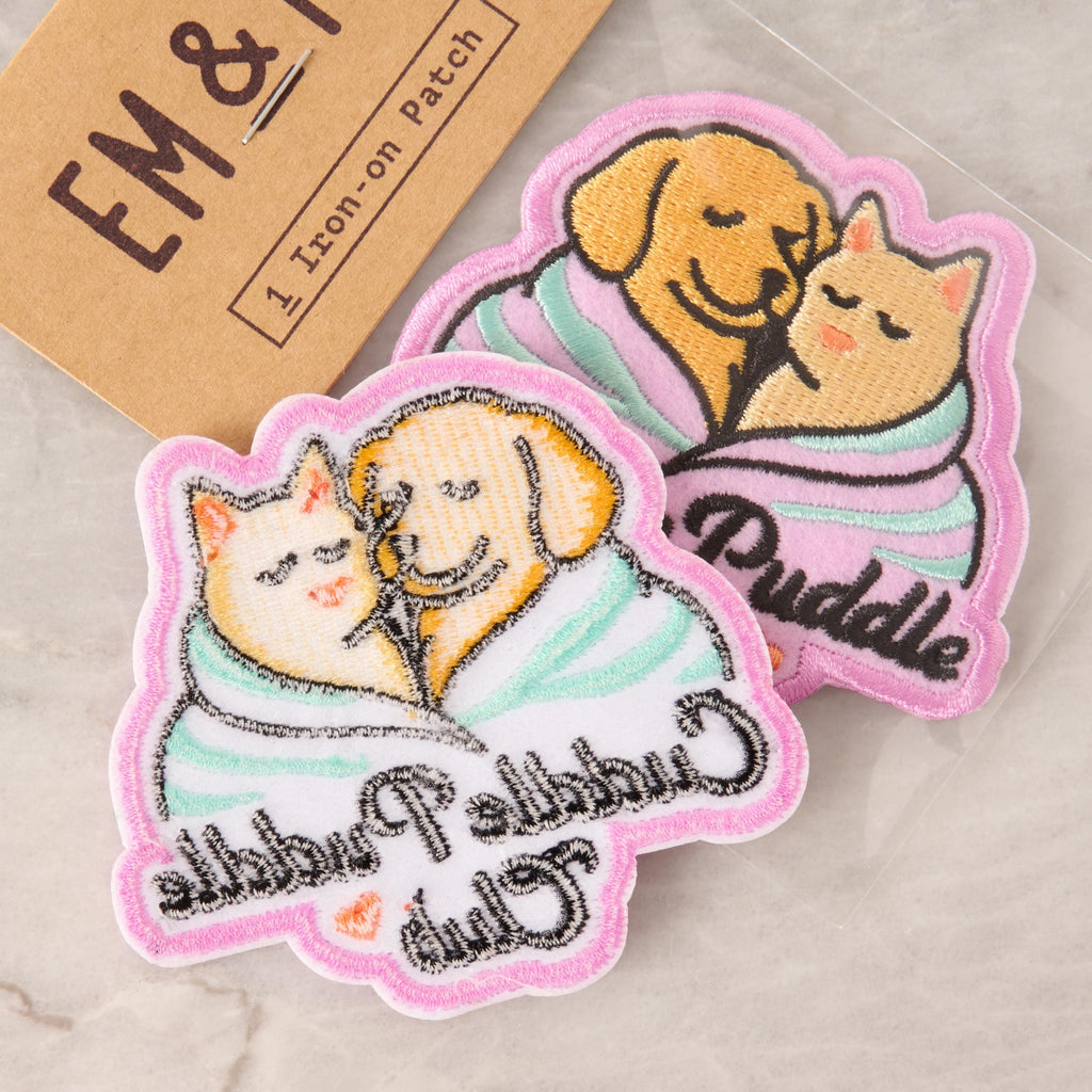 Back side of Cuddle Puddle Club patch showing heat-activated iron-on adhesive