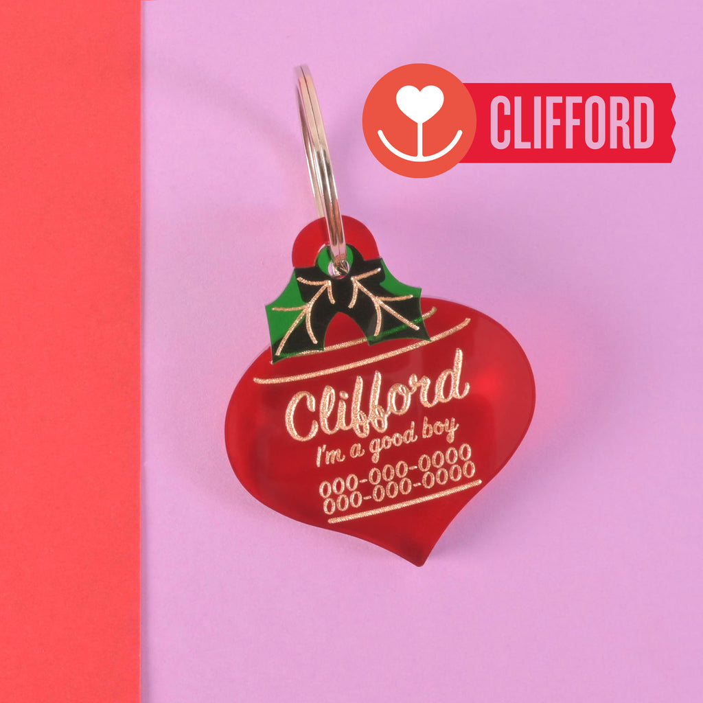Red Christmas ornament-shaped acrylic dog tag with gold engraving and green holly detail – personalized pet ID tag for Big Dogs this holiday