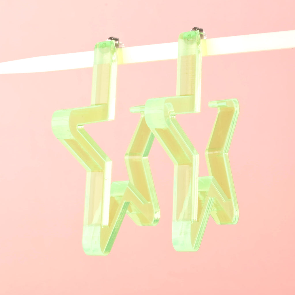 Fluorescent Green Star-shaped Hoop earrings on solid pink background