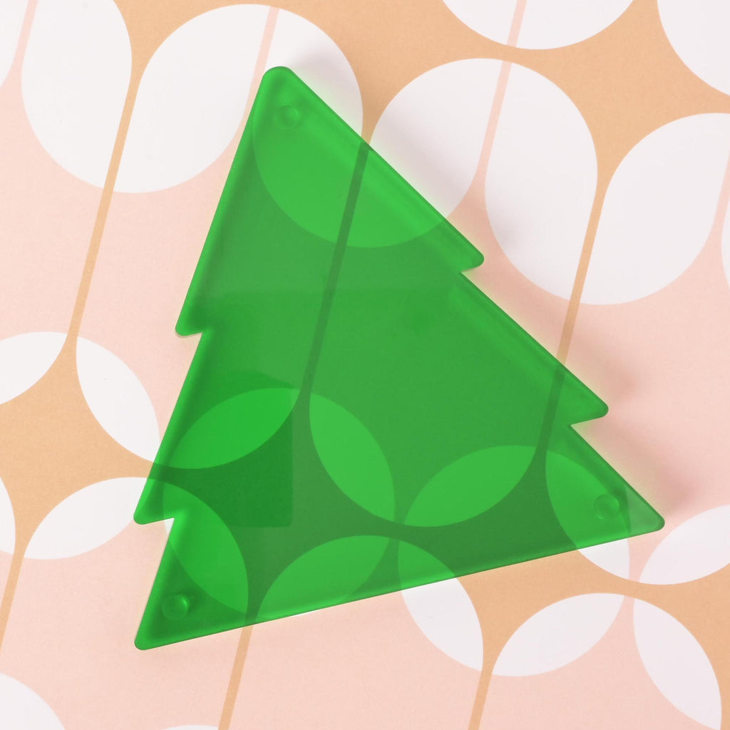 Flat lay of green acrylic Christmas tree ornament on retro-patterned background – modern holiday decor for tree trimming or gifting