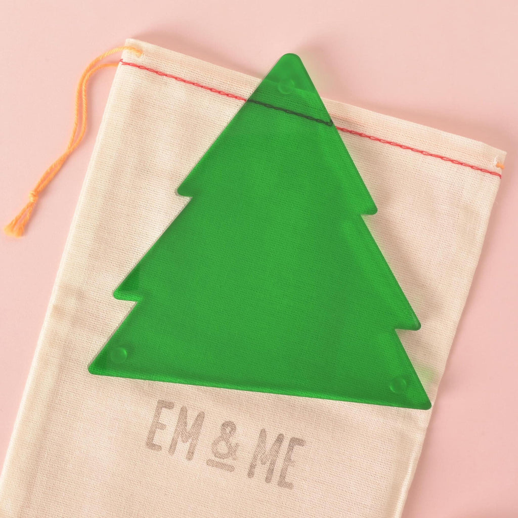 Green acrylic Christmas tree ornament on cotton drawstring bag with EM & ME branding – modern holiday packaging for gifting
