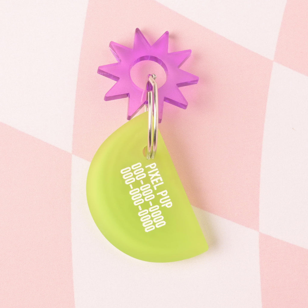 Frosted Lime colored lemon wedge-shaped personalized pet ID tag with place holder pet name and phone numbers with purple sun mini charms on checked pink background