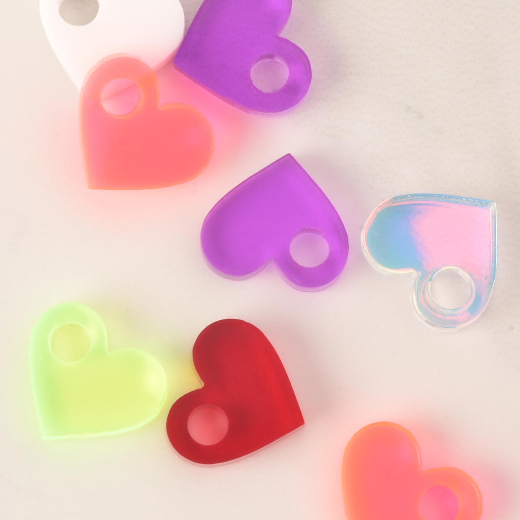 close up of a collection of tiny heart mini charms on a solid white background