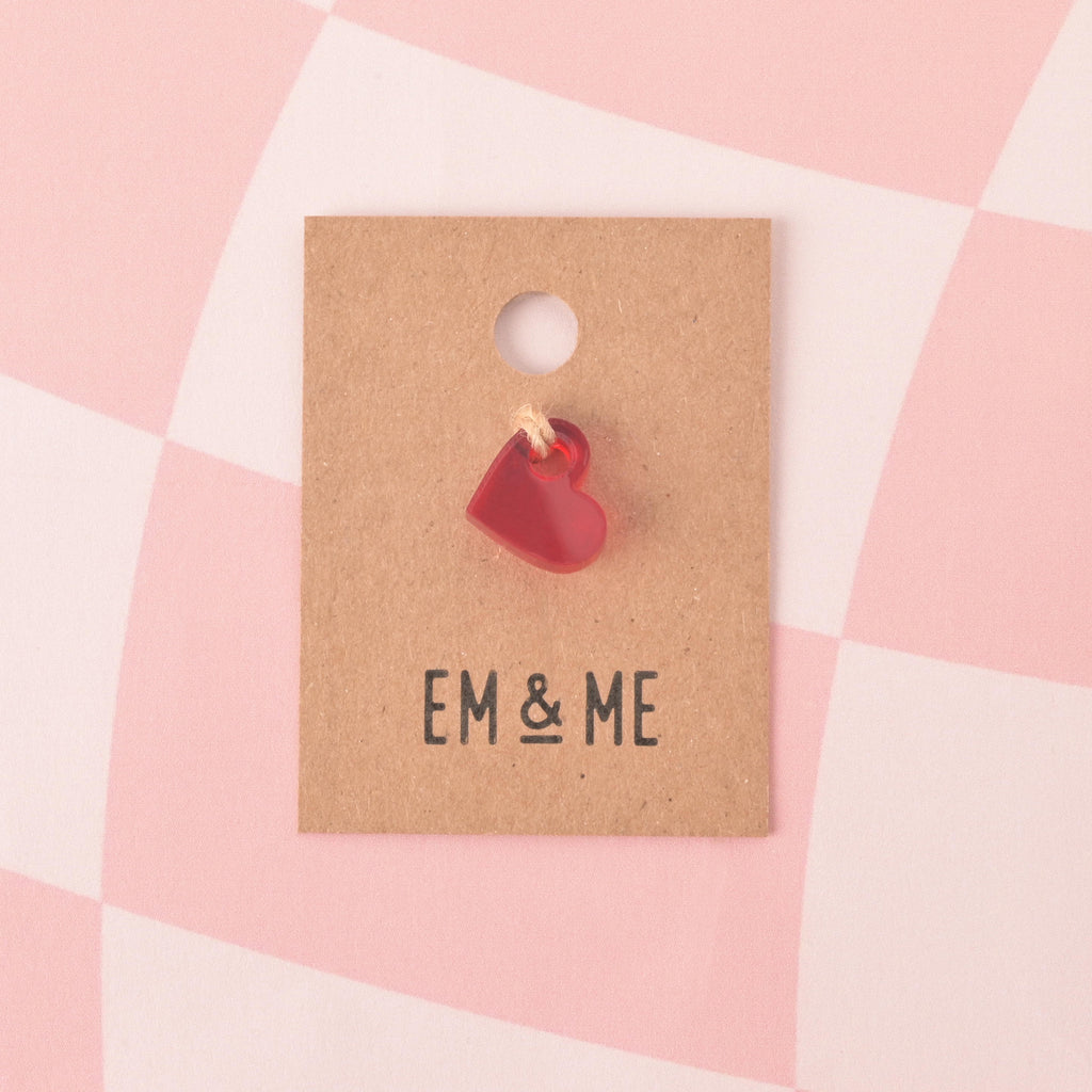 red mini heart charge on brown kraft paper card on check pink background 