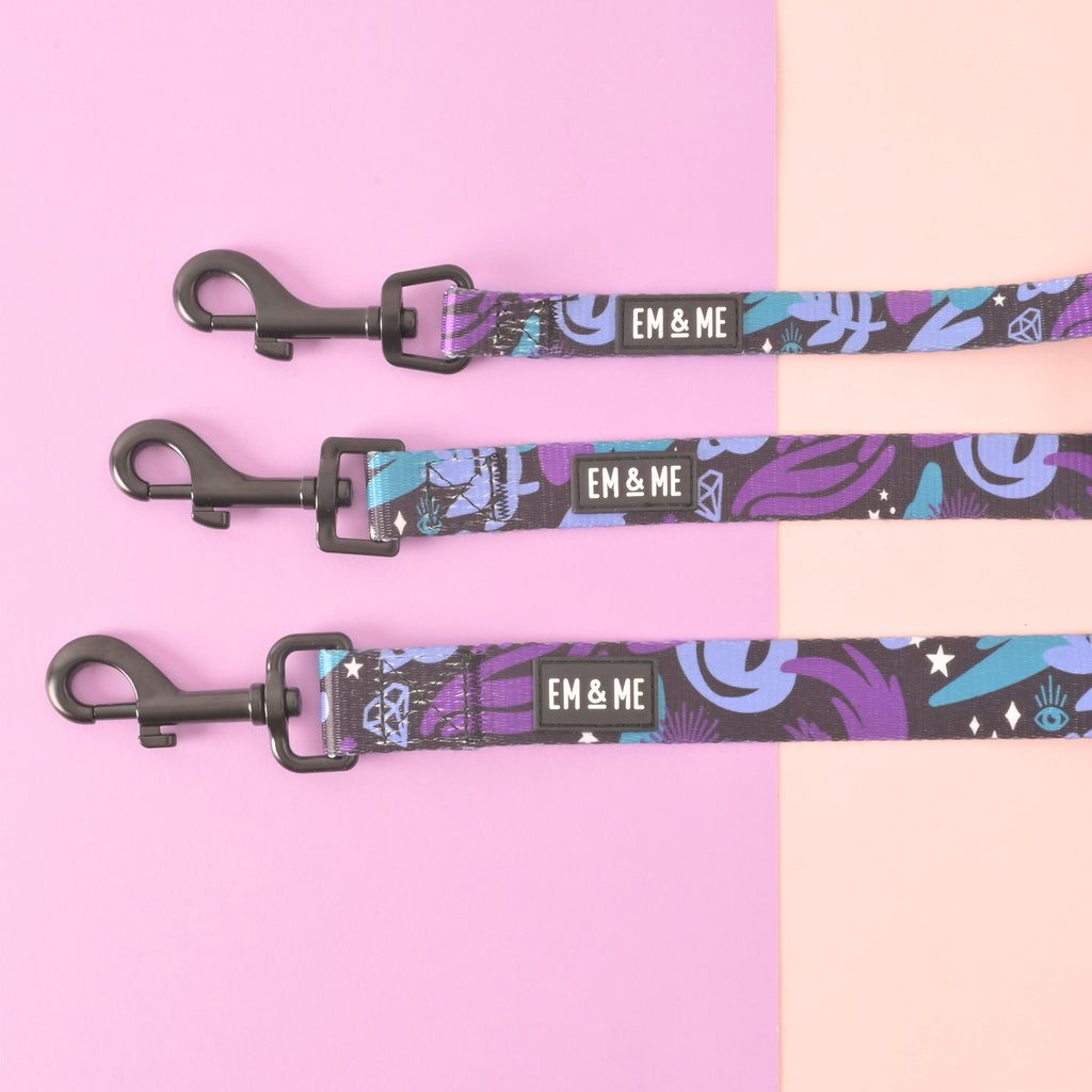 Three sizes of EM & ME spooky-themed pet leash with purple, black, and blue pattern featuring stars, moons, and mystical elements on a pastel background.