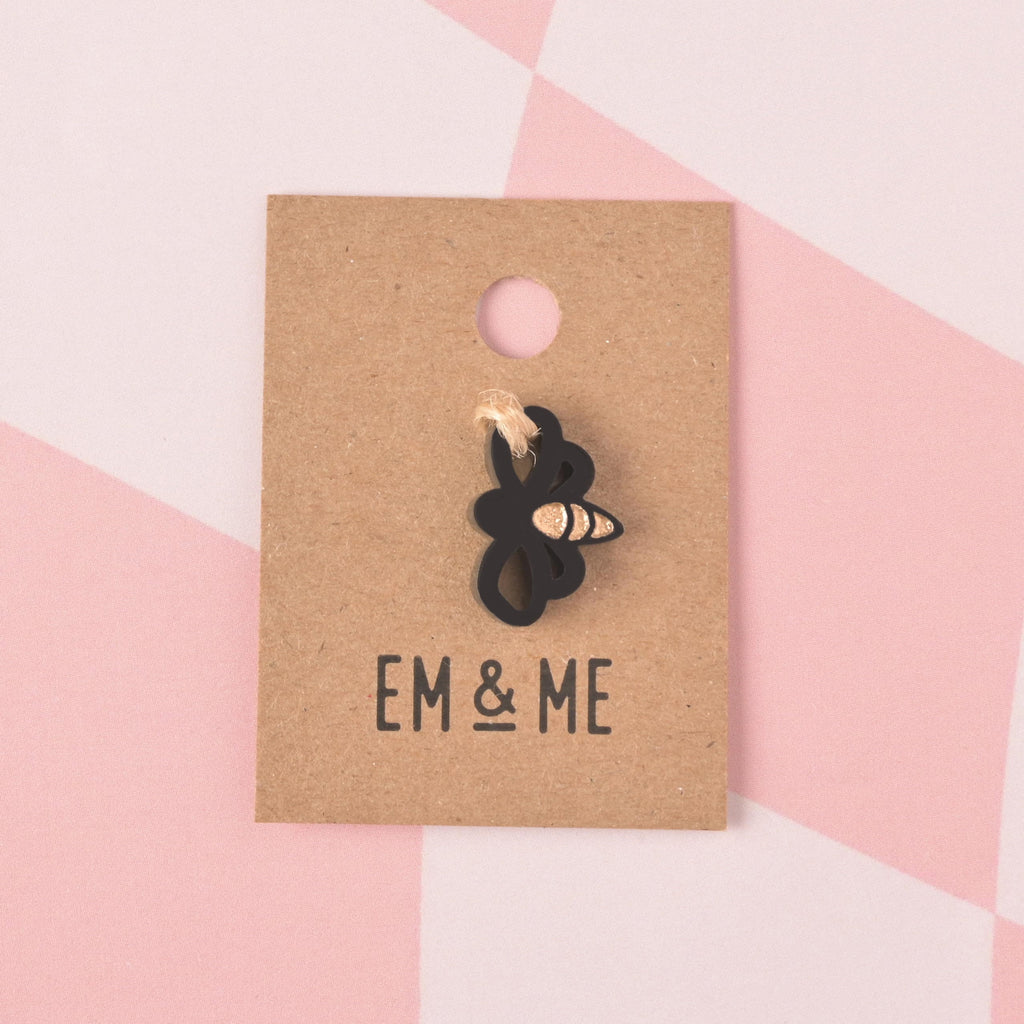 a black Bee-shaped Seasonal Mini, Tiny Honey Bee Accessory for Pet ID Tag, Cats and Dogs Add-on Charm packaged on brown kraft paper