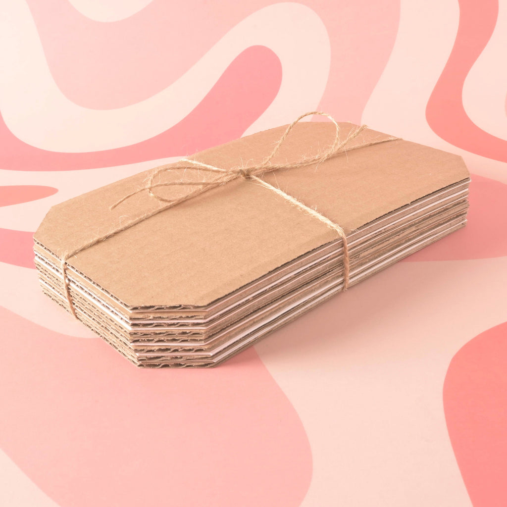 A neatly tied stack of alternating brown corrugated cardboard and white blotting paper sheets, cut in a tag shape. The refill pack is secured with natural jute twine.