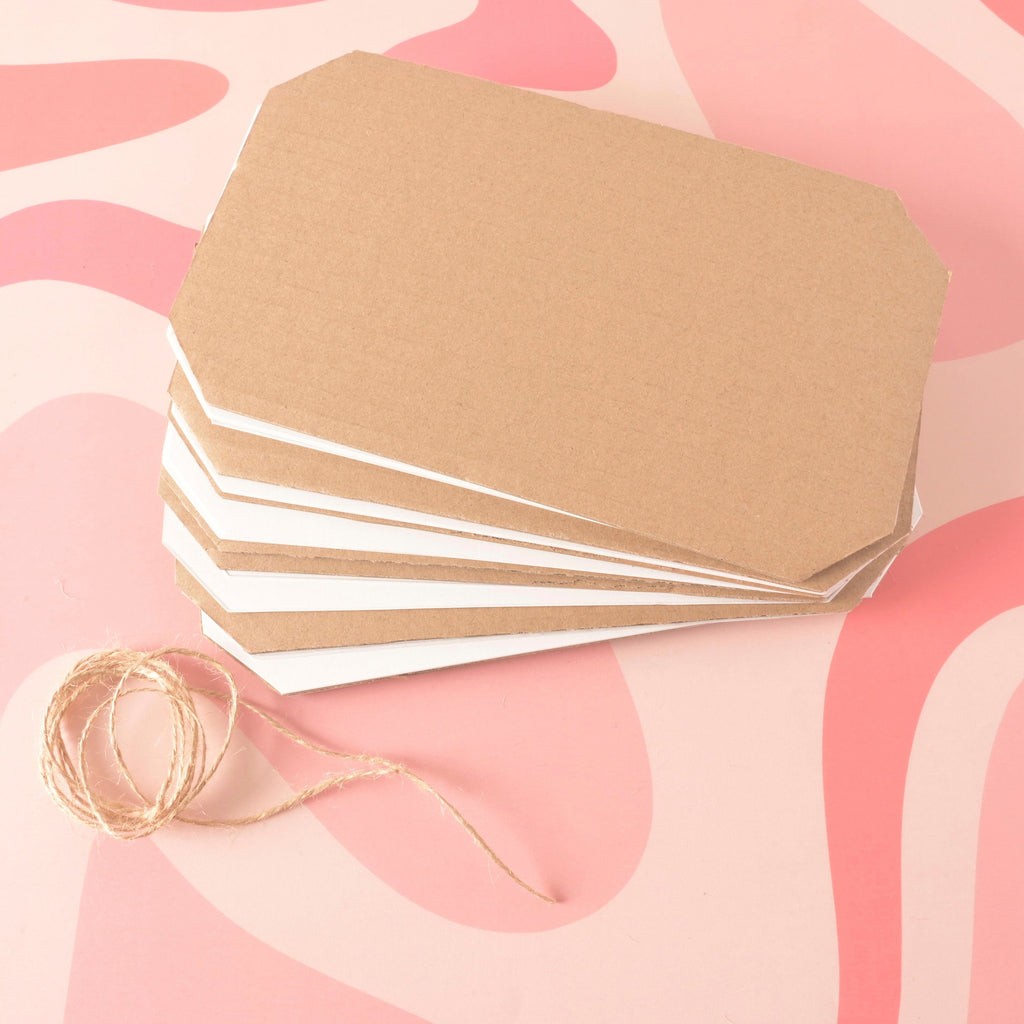 A stacked set of brown corrugated cardboard sheets layered with white absorbent blotting paper, all cut in a tag shape with rounded corners. Natural jute twine is coiled next to the stack. Flower Press Replacement Paper, 2 sets, Botanical Heirloom Flower Press