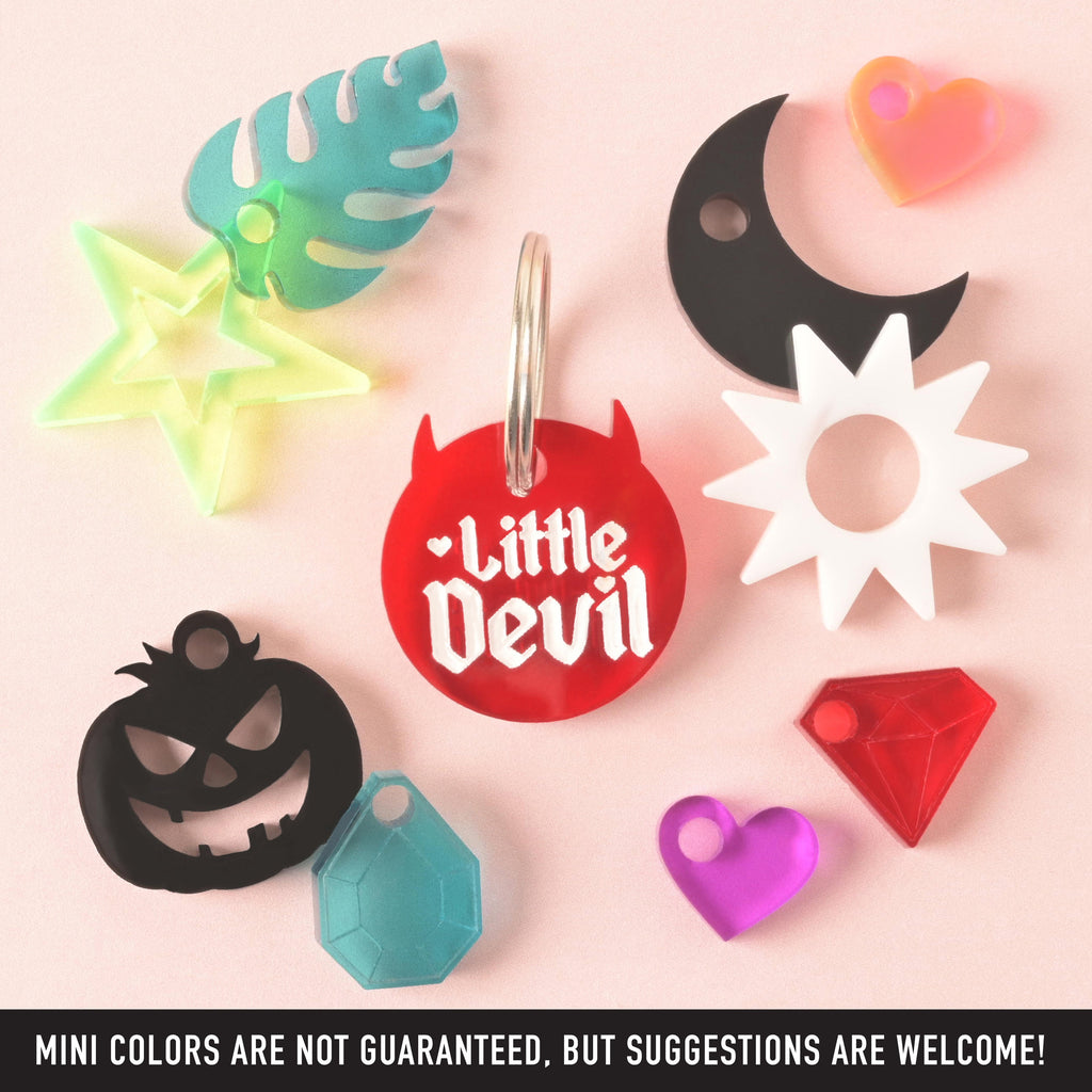 Little Devil Red Pet Tag for Dogs and Cats, personalized ID Tag for Pets with several different mini charms around on solid pink background. Bottom banner reads "MINI COLORS ARE NOT GUARANTEED< BUT SUGGESTIONS ARE WELCOME"
