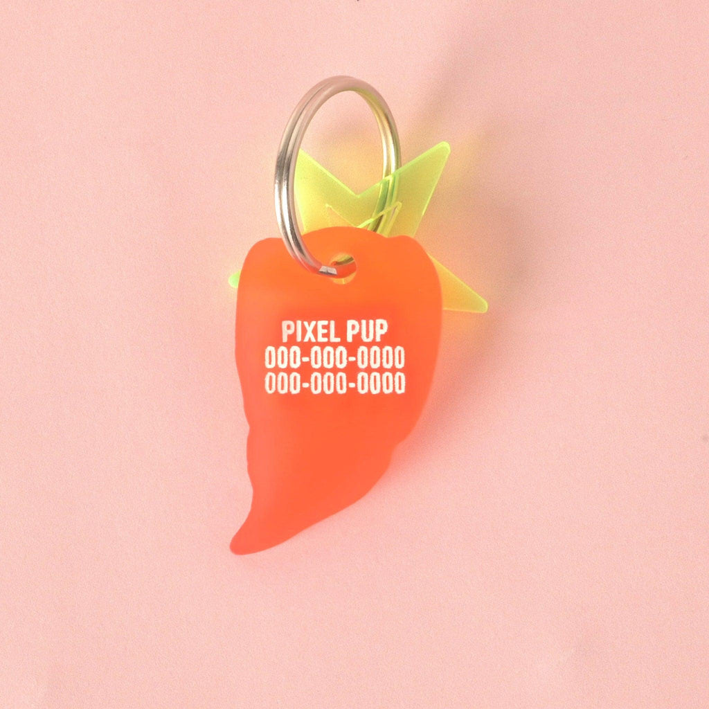 Close-up of the back of a translucent orange/red chili pepper-shaped pet ID tag. The tag is personalized with the name "PIXEL PUP" and placeholder phone numbers in white text. A neon yellow-green star charm is visible behind the tag. Spicy Hot, Pepper Personalized Pet Tag, ID for Cats and Dogs, Veggie Pet Tags