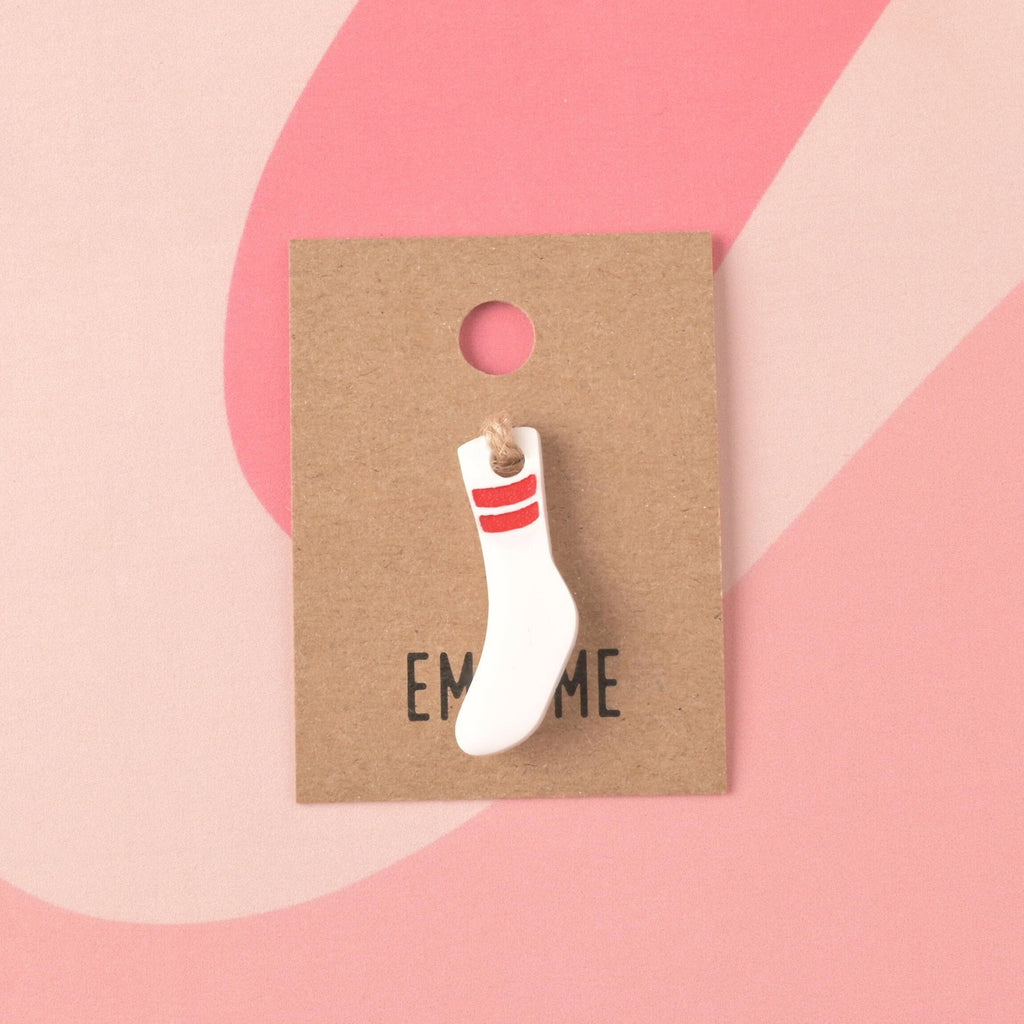  A small, opaque white acrylic mini charm shaped like a tube sock, featuring two bold red glitter stripes near the top, displayed on a pink background. Tubesock, Missing Sock, Seasonal Mini, Tiny Accessory for Pet ID Tag, Cats and Dogs Add-on Charm