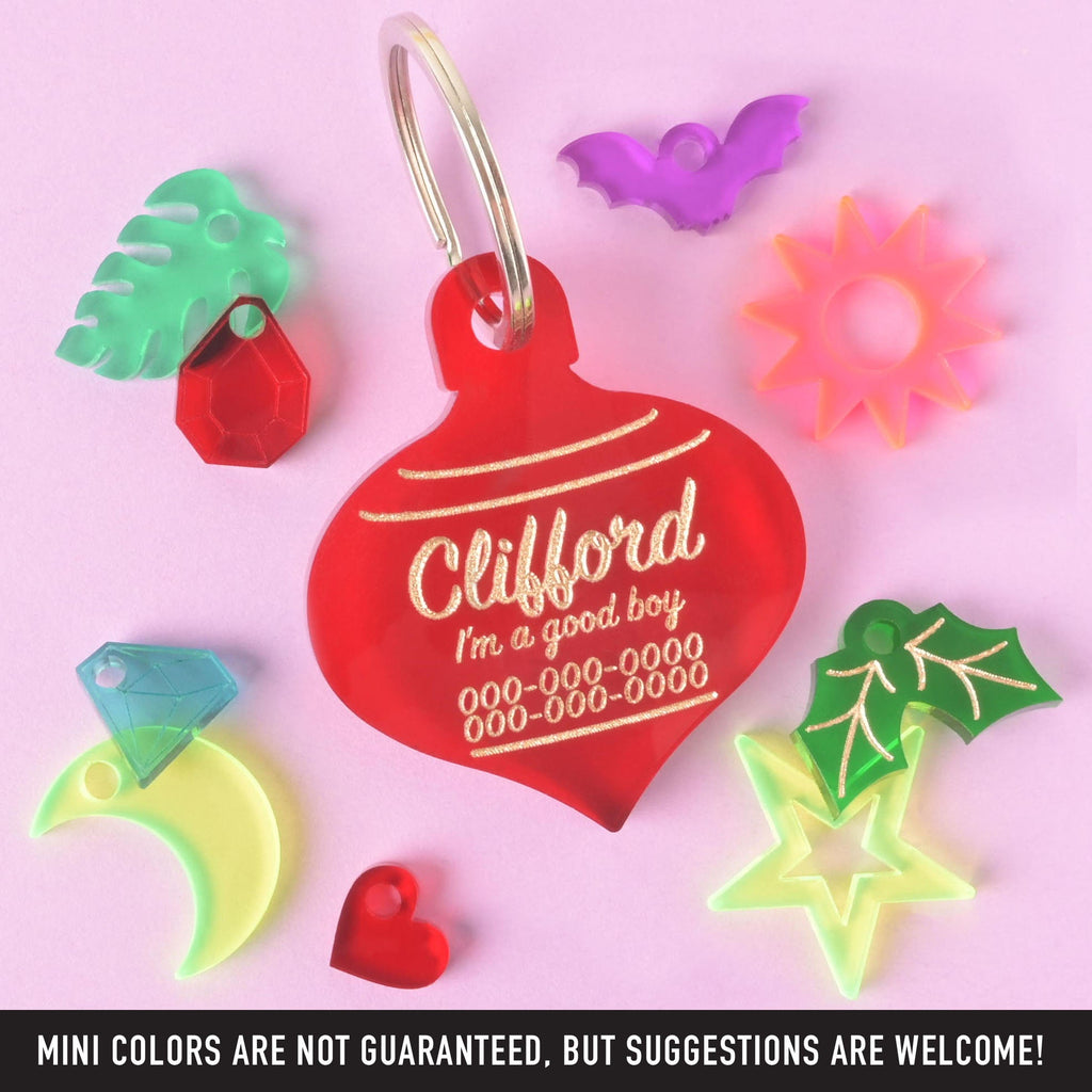 Red Christmas ornament-shaped dog tag for Clifford surrounded by colorful mini acrylic charms – custom pet tag with holiday and fun accessory options